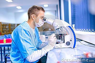 Male scientist, chemist working with microscope in pharmacy Stock Photo