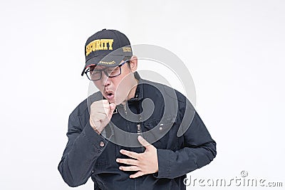 A male security guard has a bad cough clenching his chest. A male, asian and in his 40s, clearing his throat of phlegm. Isolated Stock Photo