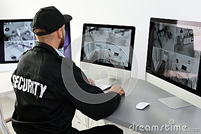 Male security guard monitoring home cameras Stock Photo