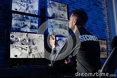 Male security guard with portable transmitter monitoring modern CCTV cameras Stock Photo
