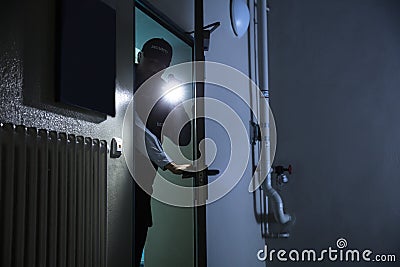 Male Security Guard Searching With Flashlight Stock Photo