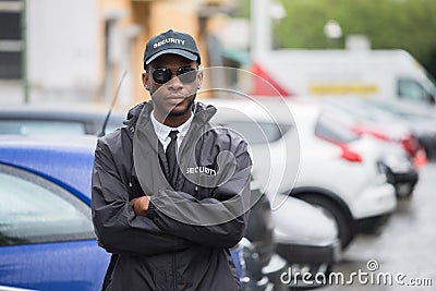 Male Security Guard Standing Arms Crossed On Street Stock Photo