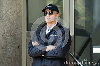 Male Security Guard Standing At The Entrance Stock Photo