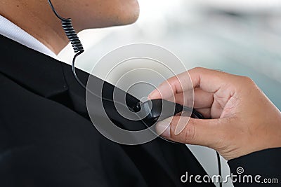 Male security guard using portable radio outdoors Stock Photo