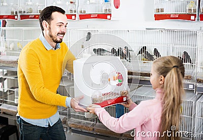 Male seller offering cage with canary bird Stock Photo