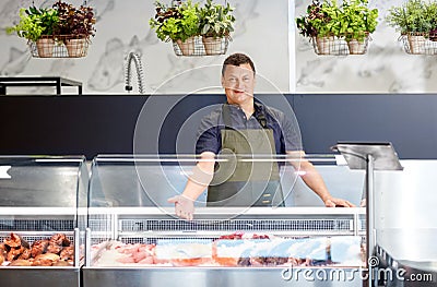 Male seller showing seafood at fish shop fridge Stock Photo