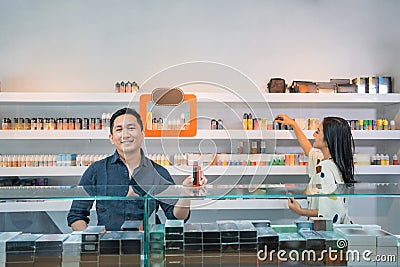 male seller standing put the vape mod on the display table Stock Photo