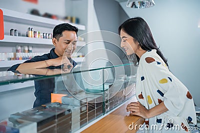 male shopkeeper explaining the variants of the vape mod Stock Photo