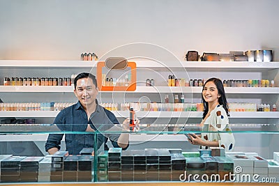 male shopkeeper standing put the vape mod on the display table Stock Photo