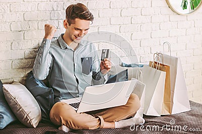 Male shopper celebrating sucessful shopping at online retail store Stock Photo