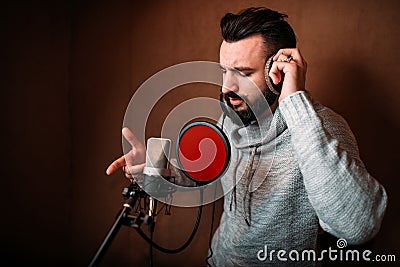 Male singer recording a song in music studio Stock Photo