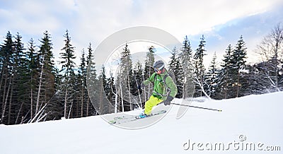 Male skier backpacker extremal freeriding skiing on ski desert wooded slope. Carving turn technique on snowy mountain. Stock Photo