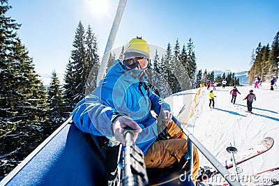 Male skier using selfie stick taking photos while skiing Stock Photo