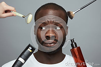 Male Skin Care. Facial Beauty Treatment For African Model. Jade Roller, Electric Razor, Makeup Brush And Liquid In Bottle. Stock Photo