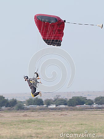 Male skydiver coming in for extra fast landing on grass with ope Editorial Stock Photo