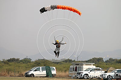 Male skydiver coming in for landing on grass with open brightly Editorial Stock Photo