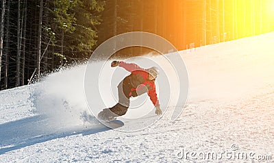 Male snowboarder slides down from the mountain in winter day Stock Photo