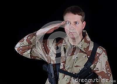 Male Soldier giving salute while under arms Stock Photo