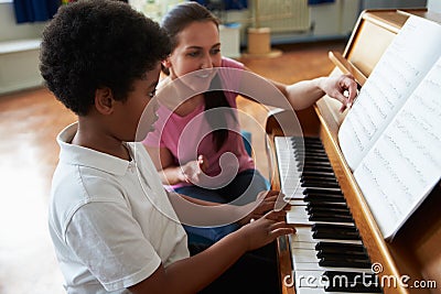 Male Student Enjoying Piano Lesson With Teacher Stock Photo