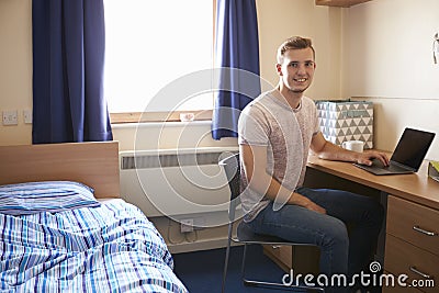 Male Student Working In Bedroom Of Campus Accommodation Stock Photo