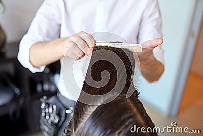 Male stylist hands combing wet hair at salon Stock Photo