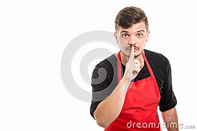 Male supermarket employer showing silence gesture Stock Photo