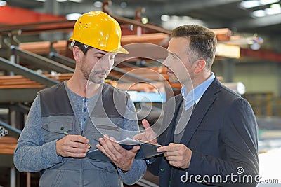 Male supervisor talking with worker in metal industry Stock Photo