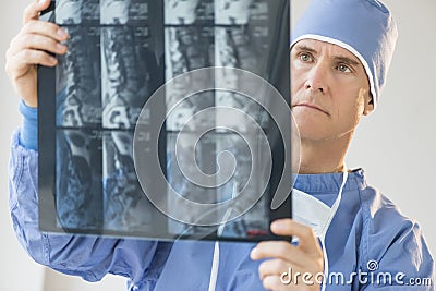 Male Surgeon Examining X-Ray Report Stock Photo