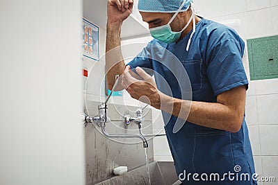 Male surgeon washing hands prior to operation using correct technique for cleanliness Stock Photo