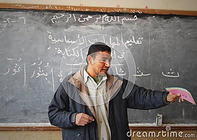 Male teacher in classroom explaining on blackboard Editorial Stock Photo