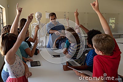 Male teacher using a model of a human skeleton to teach Stock Photo