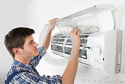 Male Technician Cleaning Air Conditioning System Stock Photo