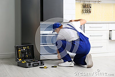 Male technician repairing broken refrigerator Stock Photo