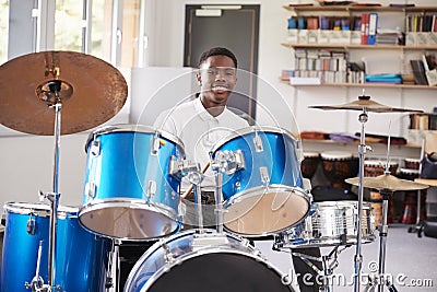 Male Teenage Pupil Playing Drums In Music Lesson Stock Photo