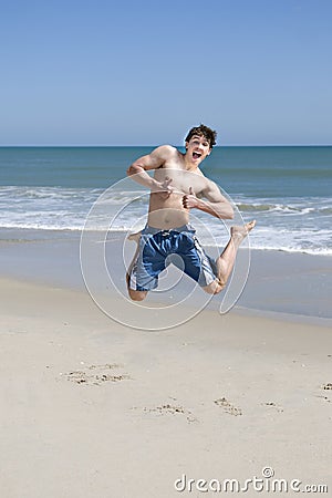 Male Teenager Jumping On Beach Stock Photo