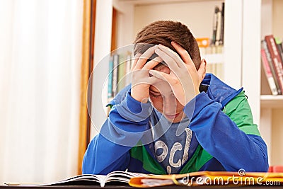 Male teenager worried doing homework Stock Photo