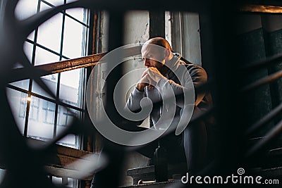 Male theif with bottle of alcohol sits on stairs Stock Photo