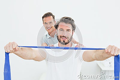 Male therapist assisting young man with exercises Stock Photo