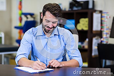 Male therapist writing on a clipboard Stock Photo