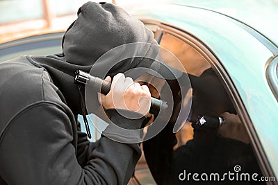 Male thief with flashlight looking inside car Stock Photo