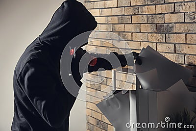Male thief with flashlight searching for documents in office Stock Photo