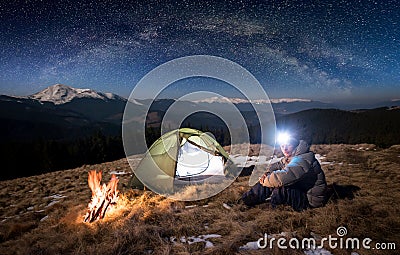 Male tourist have a rest in his camp at night under beautiful sky full of stars and milky way Stock Photo