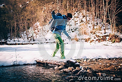 Male tourist Ñrosses a river in the mountains. Stock Photo