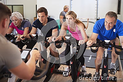 Male Trainer Taking Spin Class In Gym Stock Photo