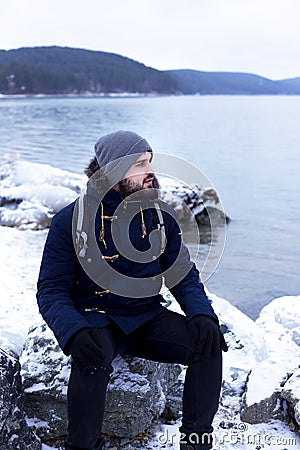 Male traveler hiker is at a mountain lake Stock Photo