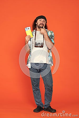 Male traveler holding his passport with airline tickets and thinking about something with his hand to his chin. Man with Stock Photo