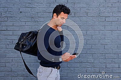 Male traveler walking with cell phone and bag Stock Photo