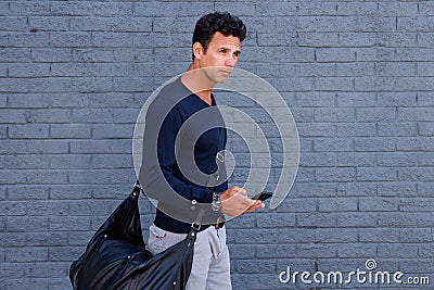 Male traveler walking with mobile phone and bag Stock Photo