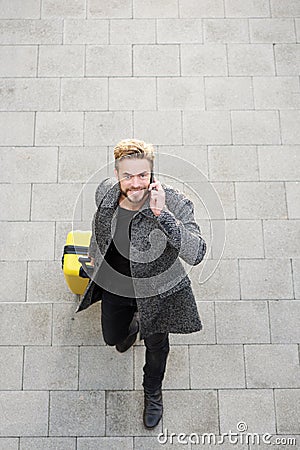 Male traveler walking with mobile phone and bag Stock Photo