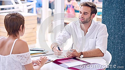 Male tutor mentoring female student in co-work space Stock Photo